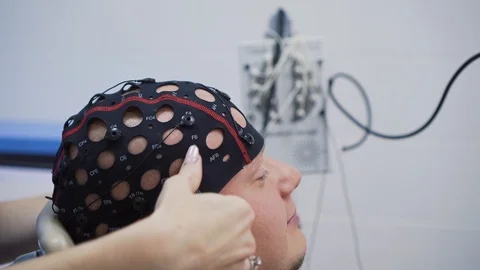 Putting on a hat with  sensors for EEG test on a man Video stock 121624343