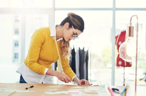 Putting her creativity to work. an attractive young fashion designer in her Stock Photos