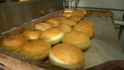Putting hot cooked donuts on baking paper Stock Footage 99614646