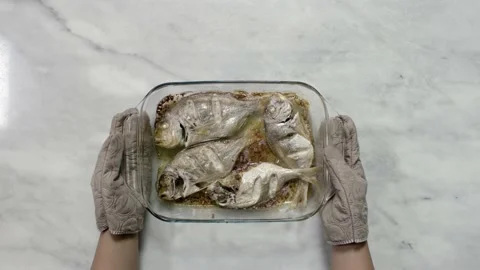 Putting hot roasted fish on the table, top view Stock Footage 135195288