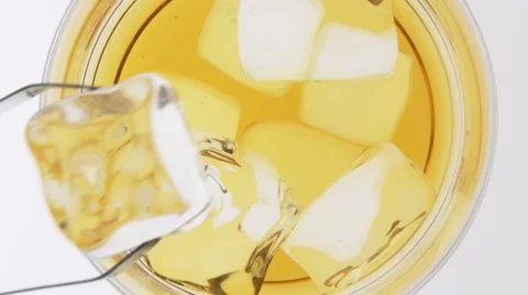 Putting ice cubes and orange peel into a glass of whisky Stock Footage