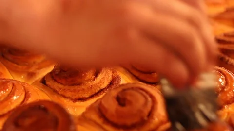 Putting icing on cinnamon rolls Stock Footage 130087815