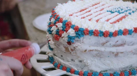 Putting icing on a red white and blue cake Stock Footage 64893691