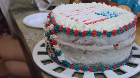 Putting icing on a red white and blue cake Video stock 64894803