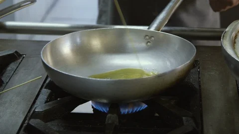 Putting ingredients in a pan on the fire Stock Footage 86203425