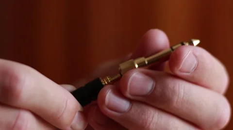 Putting a jack over a mini-jack on the headphones Vídeo Stock 64622744