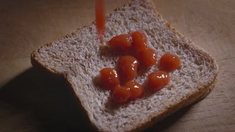 Putting ketchup on a slice of whole grain toast Stock Footage 167184029