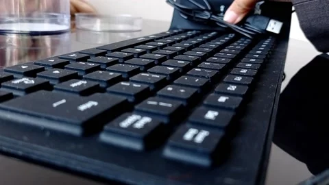 Putting a keyboard on a shiny brown table Stock Footage 146248606