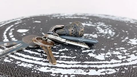 Putting keys on a table with a white background Stock Footage 145621186