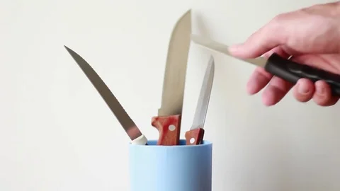 Putting knifes into the plastic box Vídeo Stock 76996124