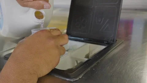 Putting laundry detergent soup in the machine Stock Footage 310228402
