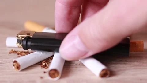 Putting lighter on the broken cigarettes Stock Footage 81584352