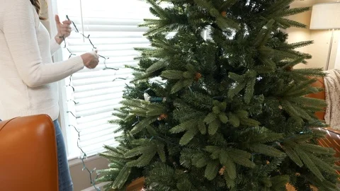 Putting lights on Christmas Tree Stock Footage 120639571