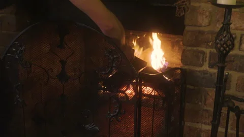 Putting a log on the fire Stock Footage 243189978