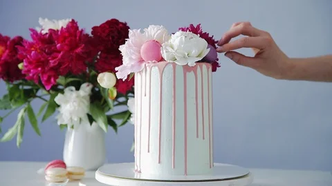 Putting macaroon cookies on the top of multilayered wedding cake, Stock Footage 105448210