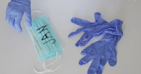 Putting mask and gloves on table. Stock Footage 137855153