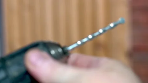 Putting in a masonry drill bit into a keyless chuck battery powered drill Vidéo 163102517