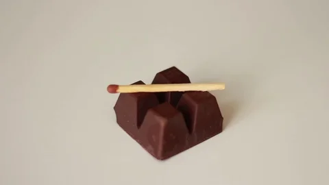 Putting match on a piece of chocolate 스톡 동영상 79785952