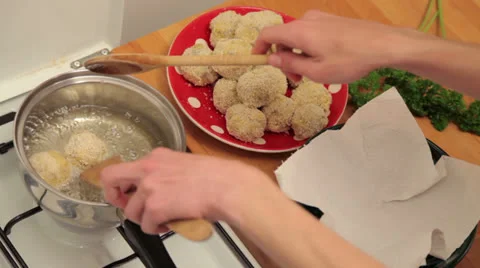 Putting meatballs in fryer Stock Footage 24672459