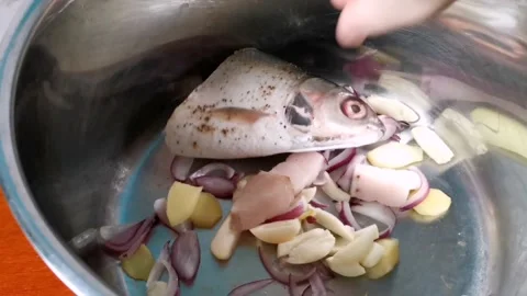 Putting Milk Fish One at a Time in a Casserole with Sauteed Onion and Garlic Stock Footage 236773985