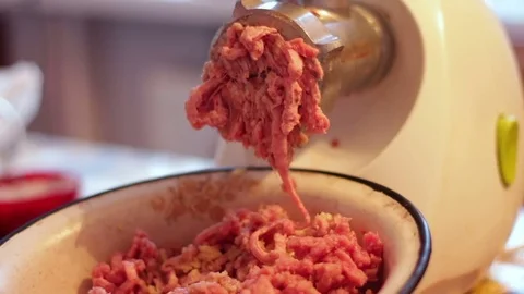 Putting minced meat and vegetable mixture through mincer at home at home Stock Footage