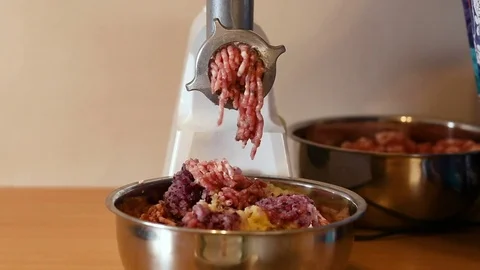 Putting minced meat and vegetable mixture through mincer at home. Stock-Footage 83061879