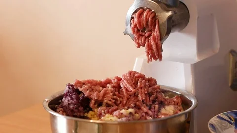 Putting minced meat and vegetable mixture through mincer at home. 스톡 동영상 83061892