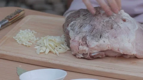 Putting mixed pepper with salt in pre-punctured pork Stock Footage 7766787