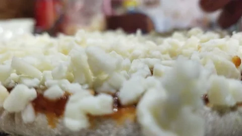Putting more cheese on pizza during preparation Stock Footage 238757550