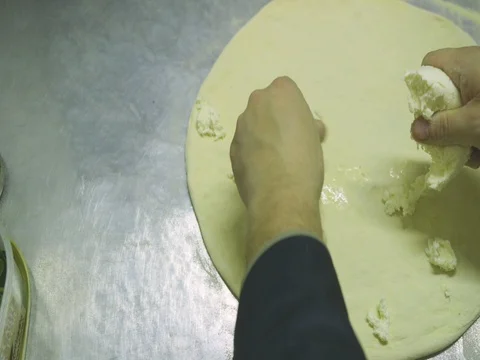 Putting mozzarella cheese on pizza dough 5 Stock Footage 80674079