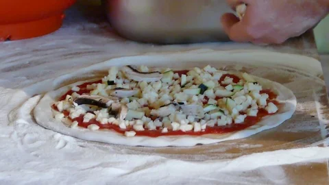 Putting mushrooms on pizza in rustic kitchen Stock Footage 77377441