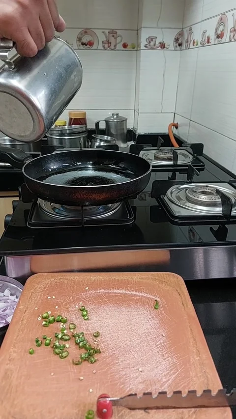 Putting oil in pan to heat up to make food Stock Footage 235484570