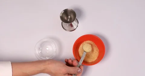Putting one table spoon of gelatin and water in glass cup to make jelly Stock Footage 107266207