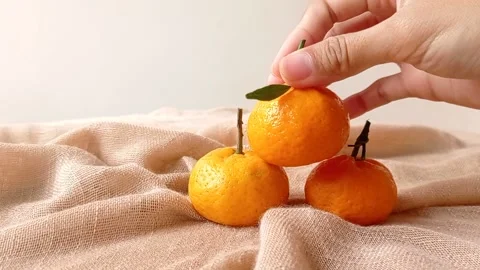 Putting oranges into a brown table Stock Footage 146259814
