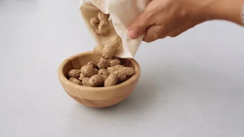 Putting out Fresh organic peanuts in the wooden bamboo bowl on the table out of Stock Footage 219617259