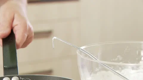 Putting pancake mixture into a frying pan Stock Footage 24635257