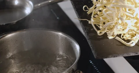 Putting pasta into the boiling water Stock Footage 124874711