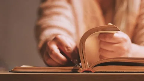 Putting a pen between the pages of an old book 库存影片 236285629