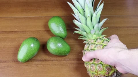 Putting pineapple to the table full of avocados 스톡 동영상 184599436