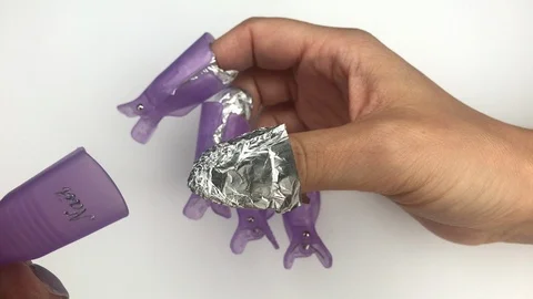 Putting on plastic reusable cap clip for soak-off UV gel polish removal. Stock Footage 117832231