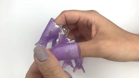 Putting off plastic reusable cap clip for soak-off UV gel polish removal. Stock Footage 117832407