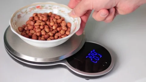 Putting a plate with peanuts on scales 動画素材 71979232