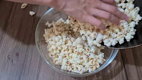 Putting the popcorn in the bowl Video stock 157443616