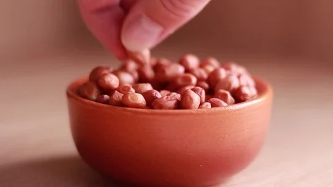 Putting pot with peanuts on the table Stock Footage 81584519