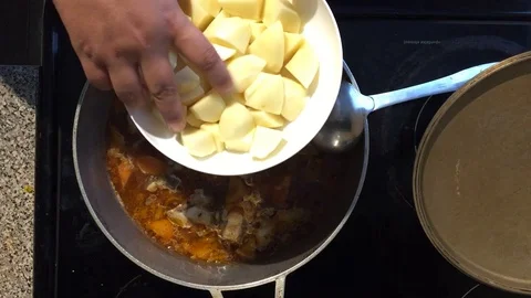 Putting Potato into soup Stock Footage 93462712