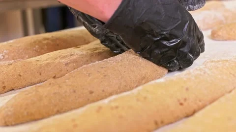 Putting raw baguettes on the table for the baking. Video stock 155523049