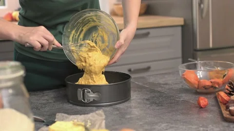 Putting raw dough into baking form cooking pumpkin pie for thanksgiving dinner Stock Footage 220792369