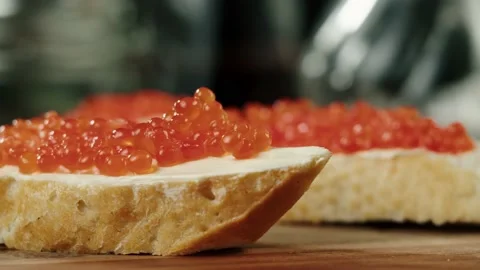 Putting red caviar on bread and butter, close-up of caviar sandwich. Salmon Video stock 159428015