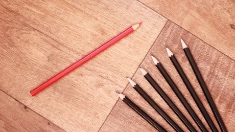 Putting red pencil beside set of black pencils 스톡 동영상 99954927