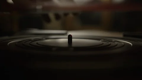 Putting a red vinyl record on turntable and putting stylus needle on Stock Footage 129587062